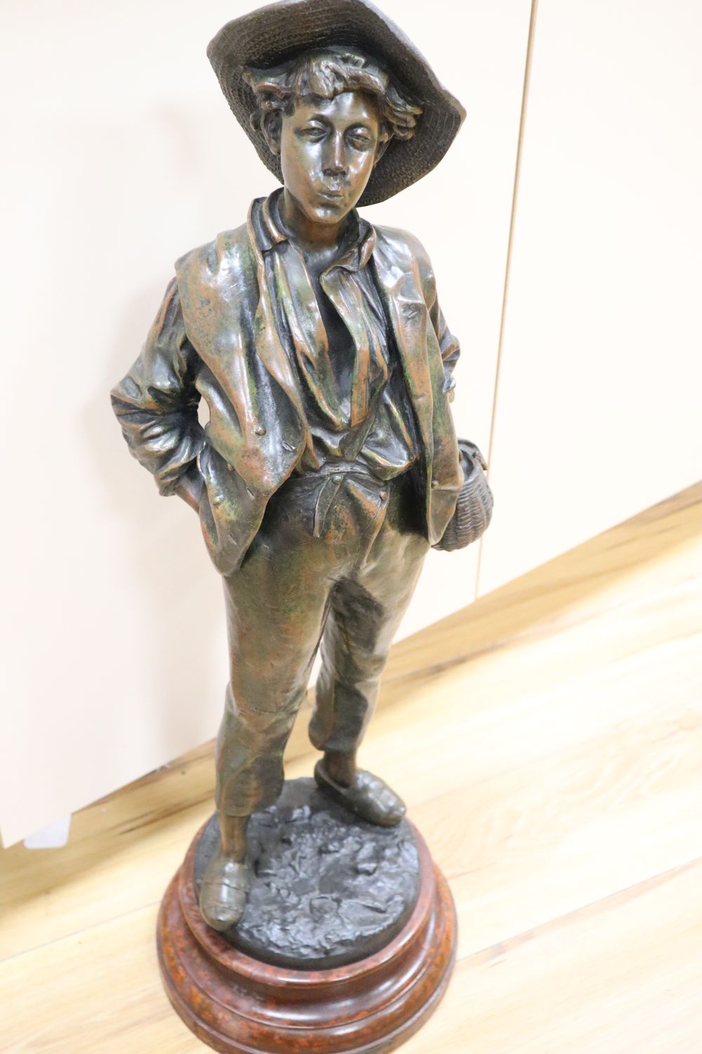 After H. Wiesse. A large patinated spelter figure of a fruit picker entitled Siffleur signed, total height 74cm
